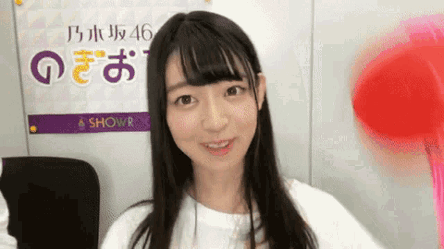 a young woman is sitting in front of a sign that says ' a show room ' on it .