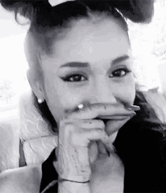 a black and white photo of ariana grande making a face .
