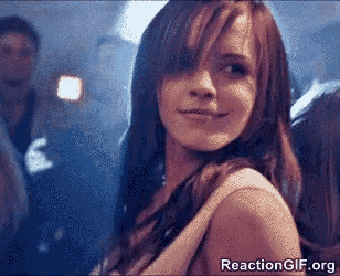 a woman with long brown hair is smiling and looking over her shoulder at the camera .