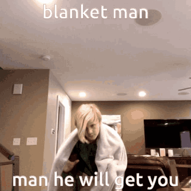 a woman is wrapped in a blanket in a living room with the caption blanket man man he will get you