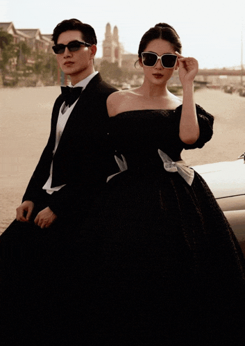 a man in a tuxedo and a woman in a black dress are posing for a picture