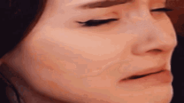 a close up of a woman 's face with her eyes closed and her mouth open