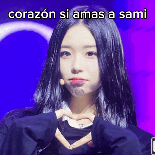 a girl is making a heart shape with her hands and the words corazon si amas a sami are above her