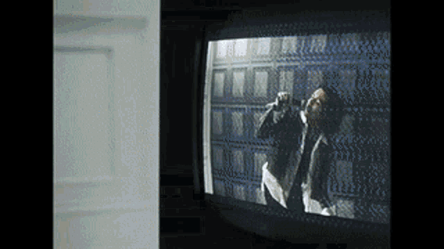 a man is singing into a microphone on a television