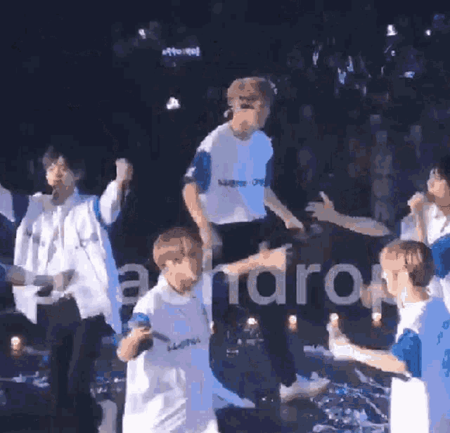 a group of young people are dancing on a stage with a sign in the background that says " a ndrop "
