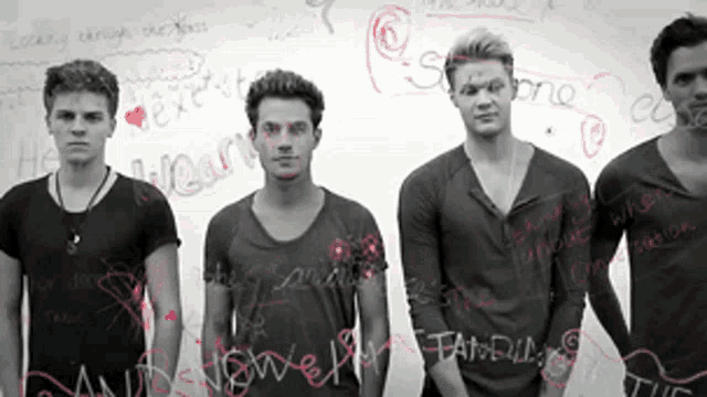 a group of young men standing in front of a white board with words written on it including " he heart "