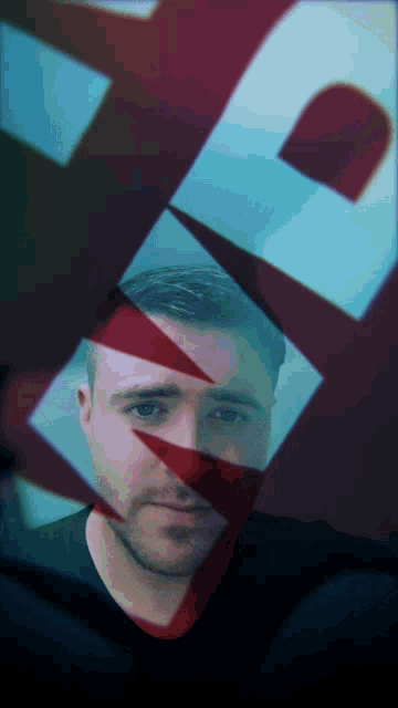 a man 's face is partially obscured by a red and blue triangle