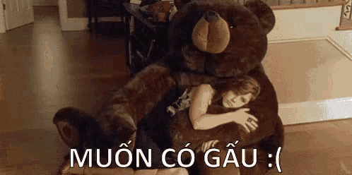 a girl is hugging a large teddy bear in a living room .