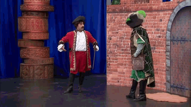 a man in a pirate costume stands next to another man in a green costume