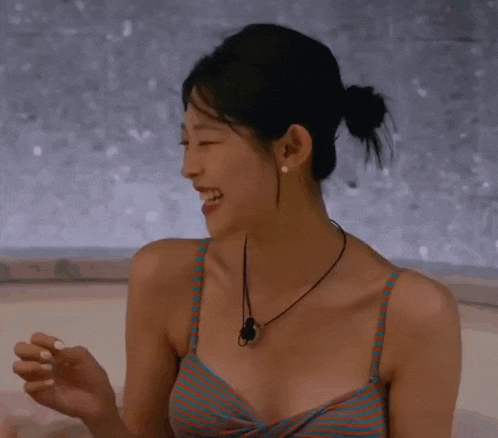 a woman in a striped bikini is laughing with her mouth wide open