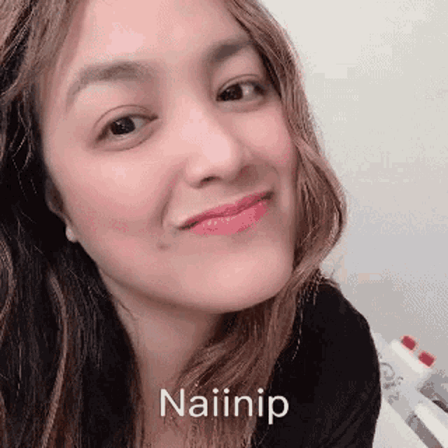 a close up of a woman 's face with the words naiinip written on the bottom of it .