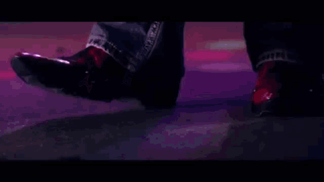 a close up of a person 's feet wearing red shoes on a stage .