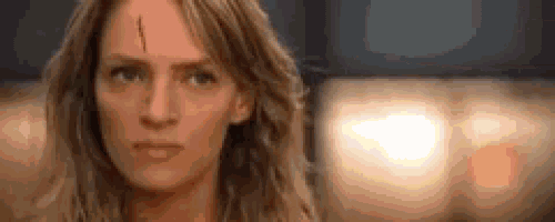 a woman with a bullet hole in her forehead is looking at the camera with a serious look on her face .