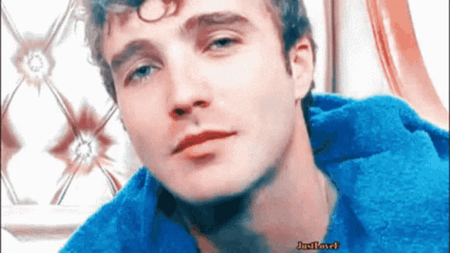 a close up of a man 's face with a blue towel around his neck and the words just play it on the bottom