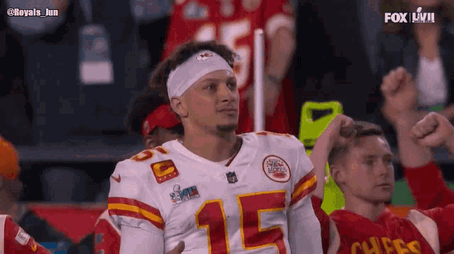 a man wearing a chiefs jersey is sitting in the stands