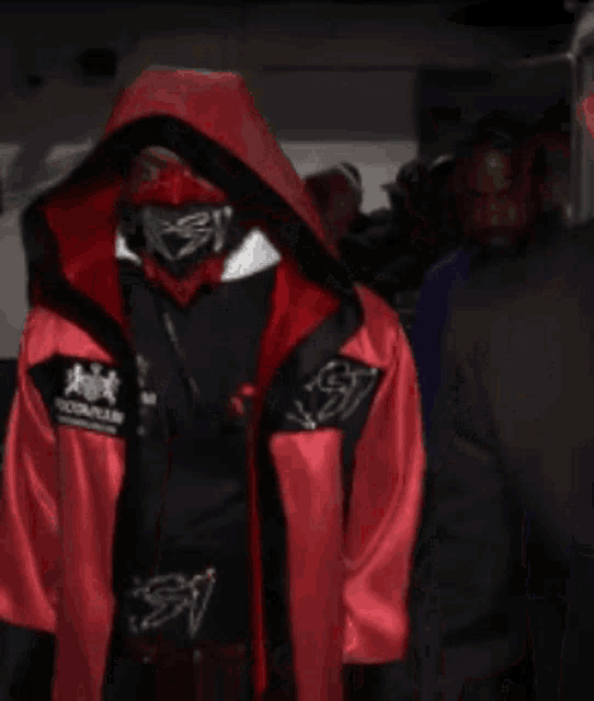 a person wearing a red jacket with a hood and a black shirt that says foot locker