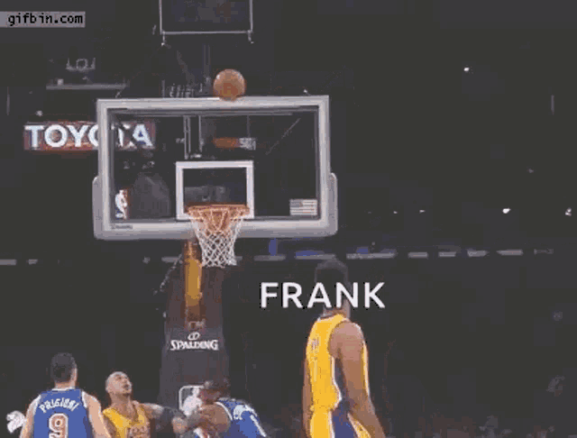 a basketball player is jumping in the air with his arms outstretched while a basketball is going through the hoop .