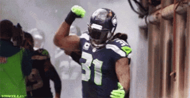 a football player wearing the number 31 jersey is flexing his muscles .