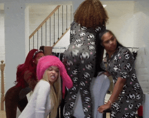 a woman wearing a pink hat is standing next to two other women in pajamas