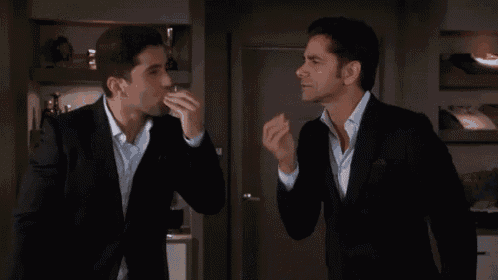 a man in a suit is eating a piece of food with his hands .