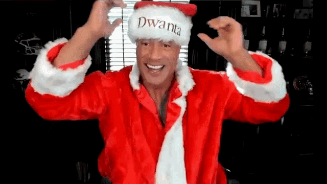 a man in a santa claus costume is making a peace sign with his hands .