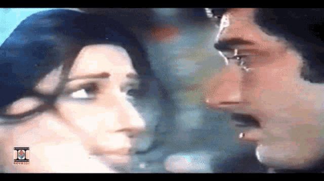 a man and a woman are looking at each other with the letters ii on the bottom of the screen