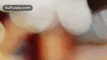 a close up of a person 's face with a blurred background and the words kulfyapp.com on the bottom .