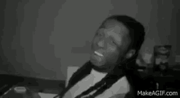 a black and white photo of a man laying down with his eyes closed and his mouth open .