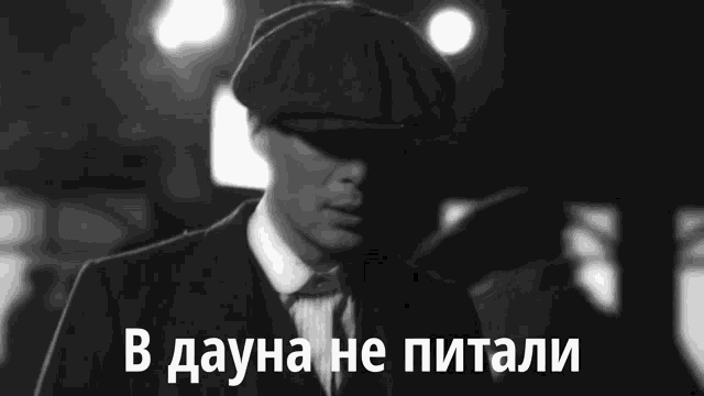 a black and white photo of a man in a suit and hat with the words in dauna he pitali in white letters