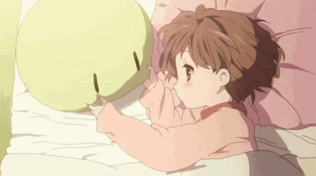 a girl laying on a bed with a pillow that looks like a face