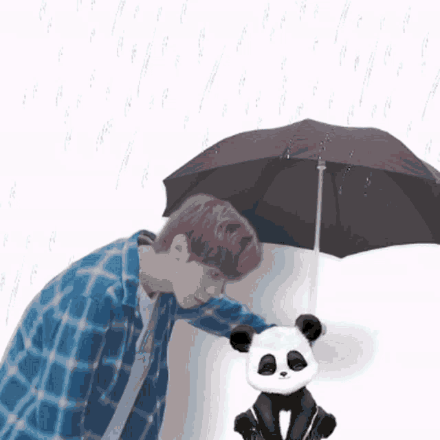 a man in a blue plaid shirt holds an umbrella over a panda bear