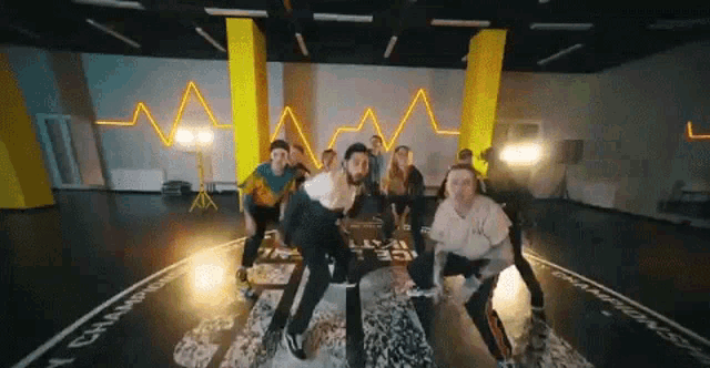 a group of people are dancing in a dance studio with a heartbeat in the background .
