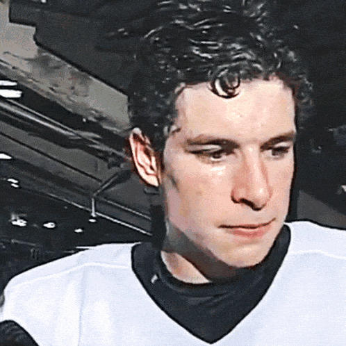 a close up of a man 's face in a white jersey