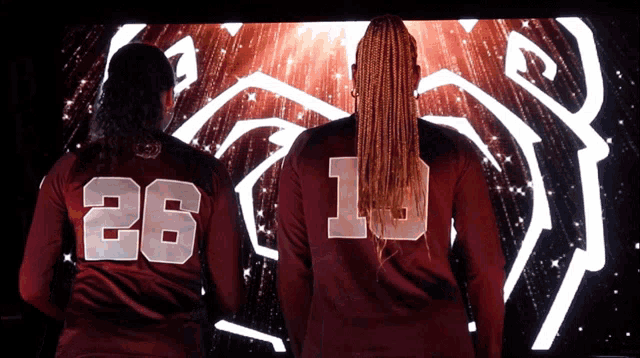 a woman wearing a jersey with the number 26 on the back
