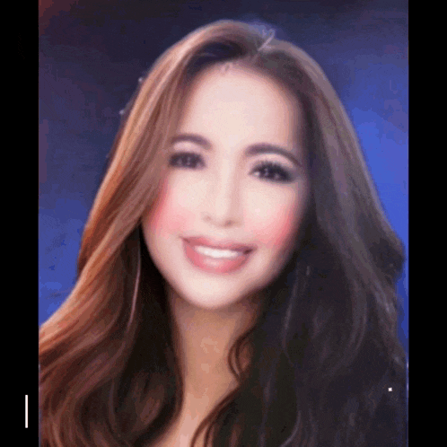 a woman with long brown hair is smiling and looking at the camera