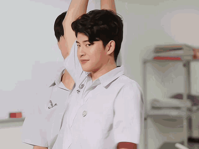 a boy wearing a white shirt with the letters u.d.a. on it
