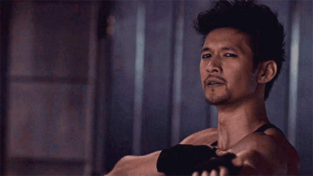 a man without a shirt is pointing his finger at something