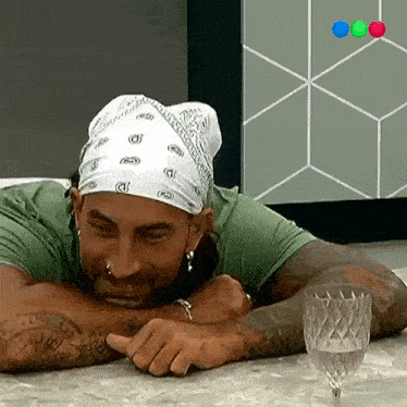 a man wearing a bandana and a green shirt is laying down