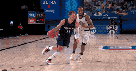 a basketball player wearing a number 77 jersey is dribbling the ball