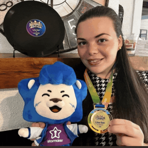 a woman is holding a stuffed animal and a medal that says lisa san on it