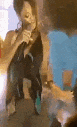 a woman is singing into a microphone while standing on a table .