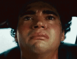 a close up of a man 's face with a tear running down his cheek .