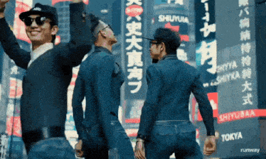 a group of men standing in front of a sign that says shiyubaa