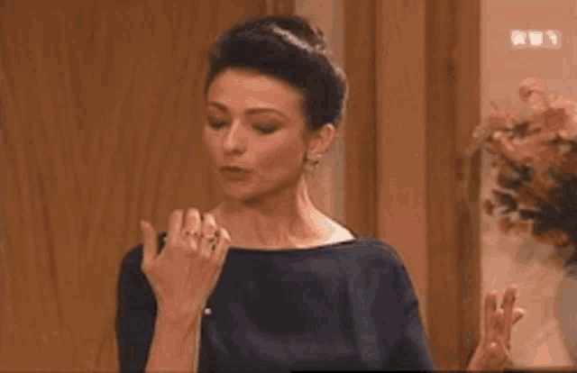 a woman in a blue dress is blowing a kiss .