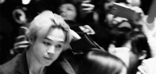a black and white photo of a man in a crowd .