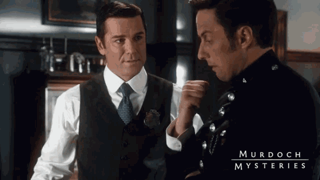 two men are standing next to each other and the words murdoch mysteries are on the bottom