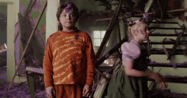 a boy and a girl are standing next to each other with purple paint on their clothes