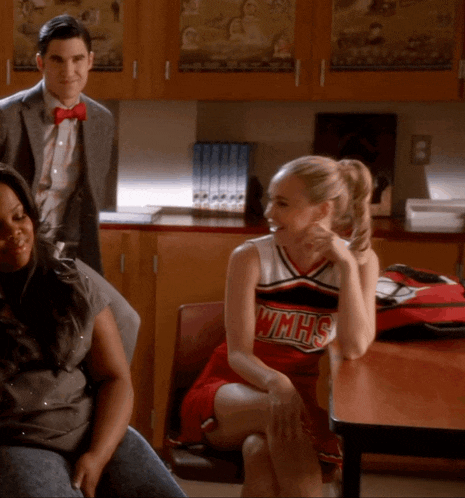 a cheerleader for wmhs sits at a table with other people