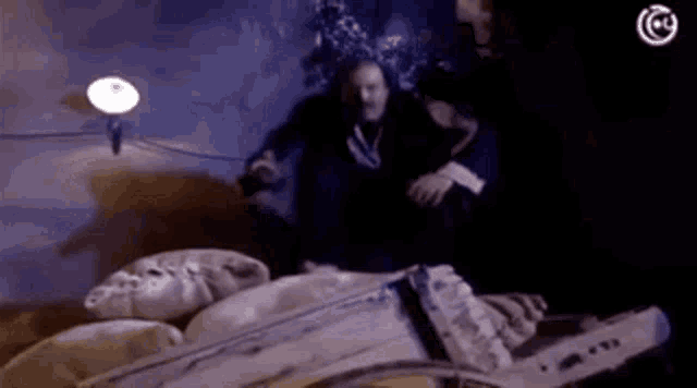 a man is sitting in a chair in a dark room with a chainsaw .