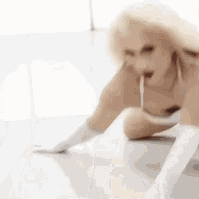 a woman is kneeling on the floor wearing white gloves and a white top .